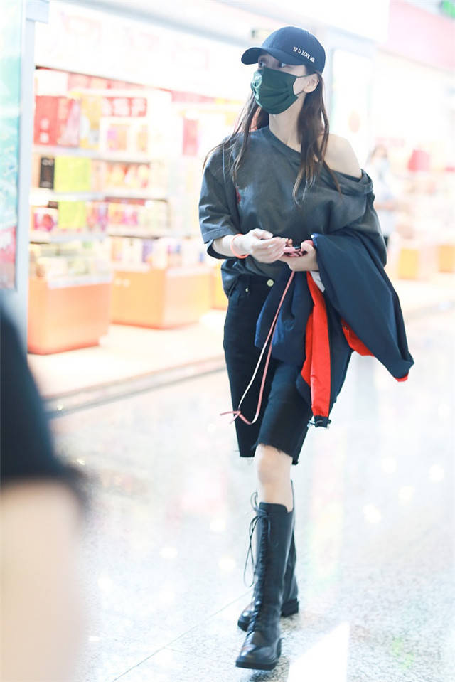 Baby现身机场穿宽松T恤秀香肩,长靴美腿抢镜