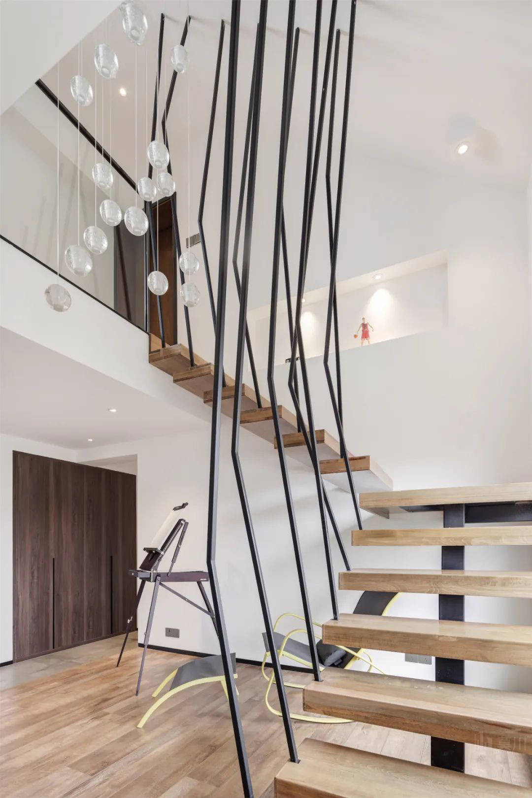 楼梯选用悬空的木质踏步梯规划,参与不规则形状的扶手,楼梯下安顿