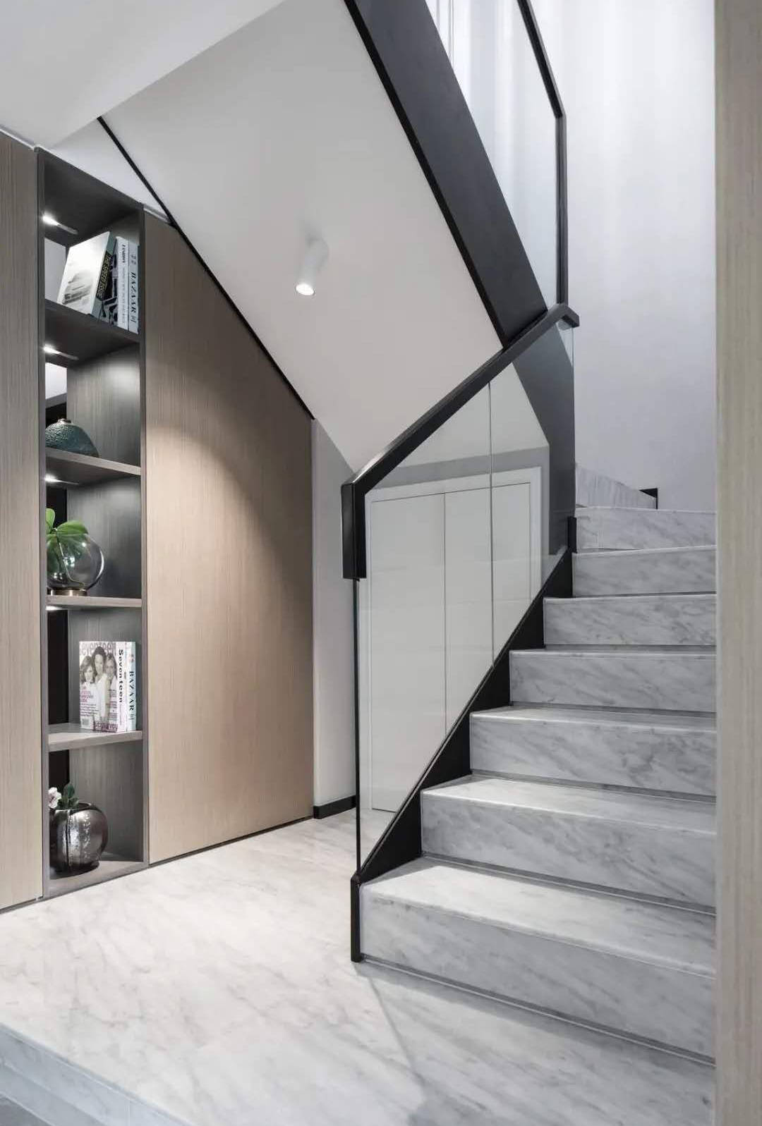 楼梯扶手是玻璃质感的,结合黑色扶手边框,在雅白的楼梯踏步地砖空间下