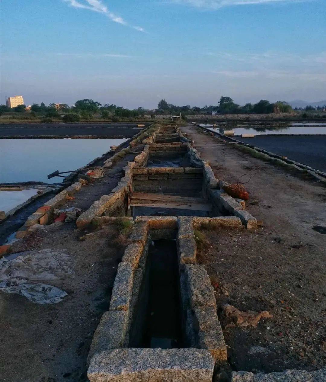 这样浸泡在盐泥(沙)上面的海水就慢慢渗滤到池底,透过盐卤水池的石头