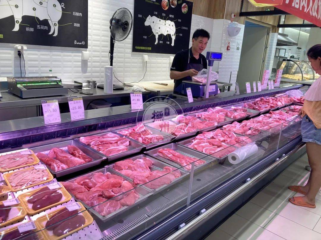 肉摊经营户王大姐和她老公正忙着给顾客称肉"这段时间猪肉确实降了些