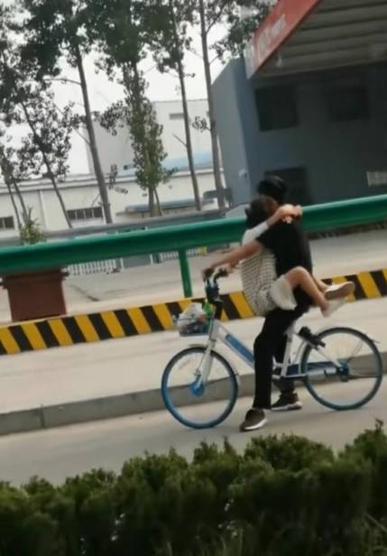 原创实拍:公路上偶遇"连体人",男女共骑一辆单车,网友直言太危险