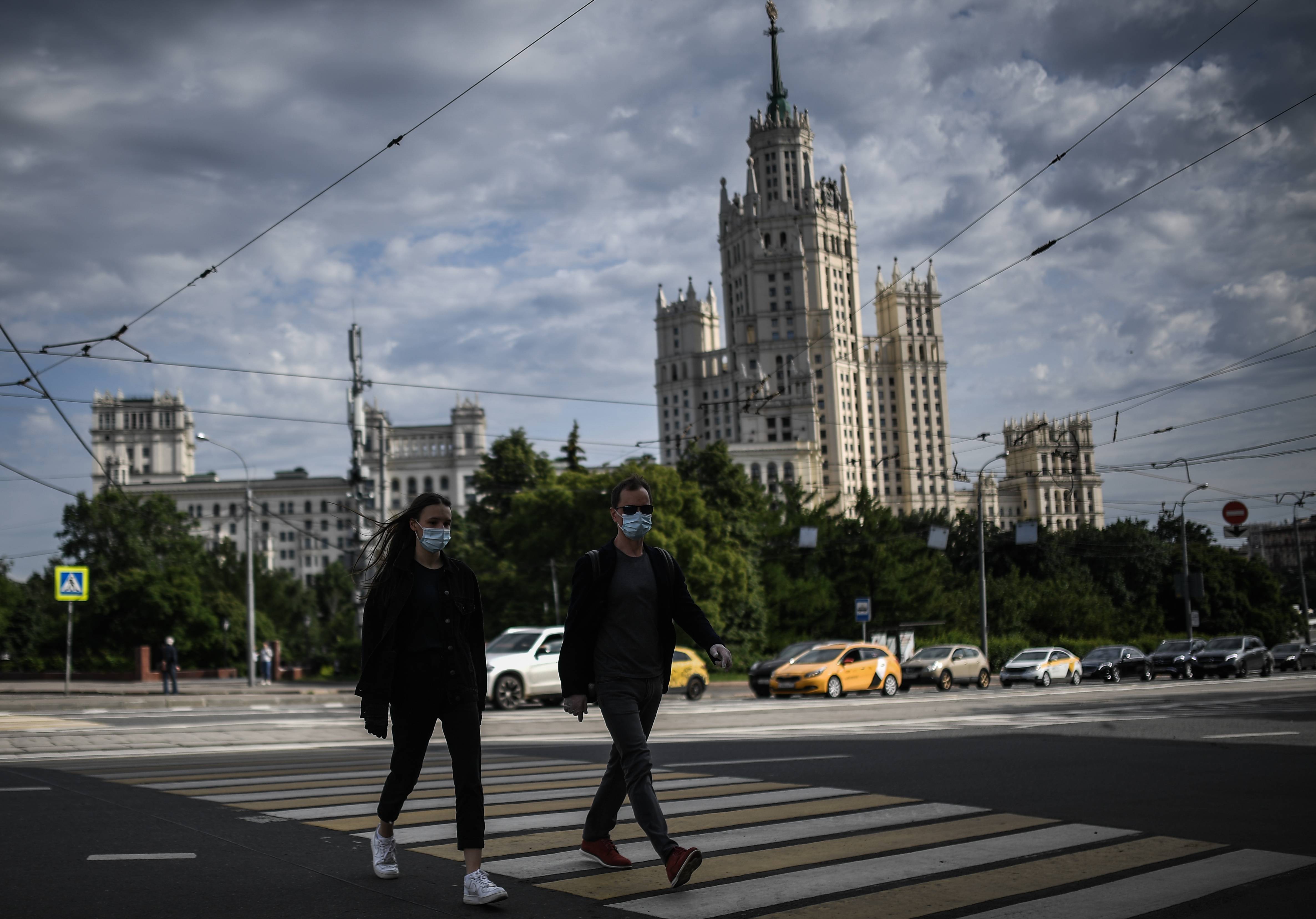 6月15日,人们戴口罩从俄罗斯莫斯科街头走过.