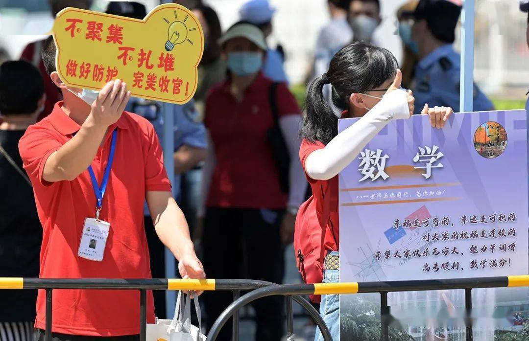 7月7日,北京市人大附中考点,八一中学送考老师手举标语为考生加油鼓劲