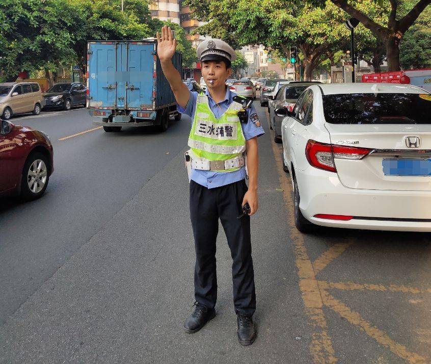 三水分局交警大队辅警张梓恩在指挥交通.