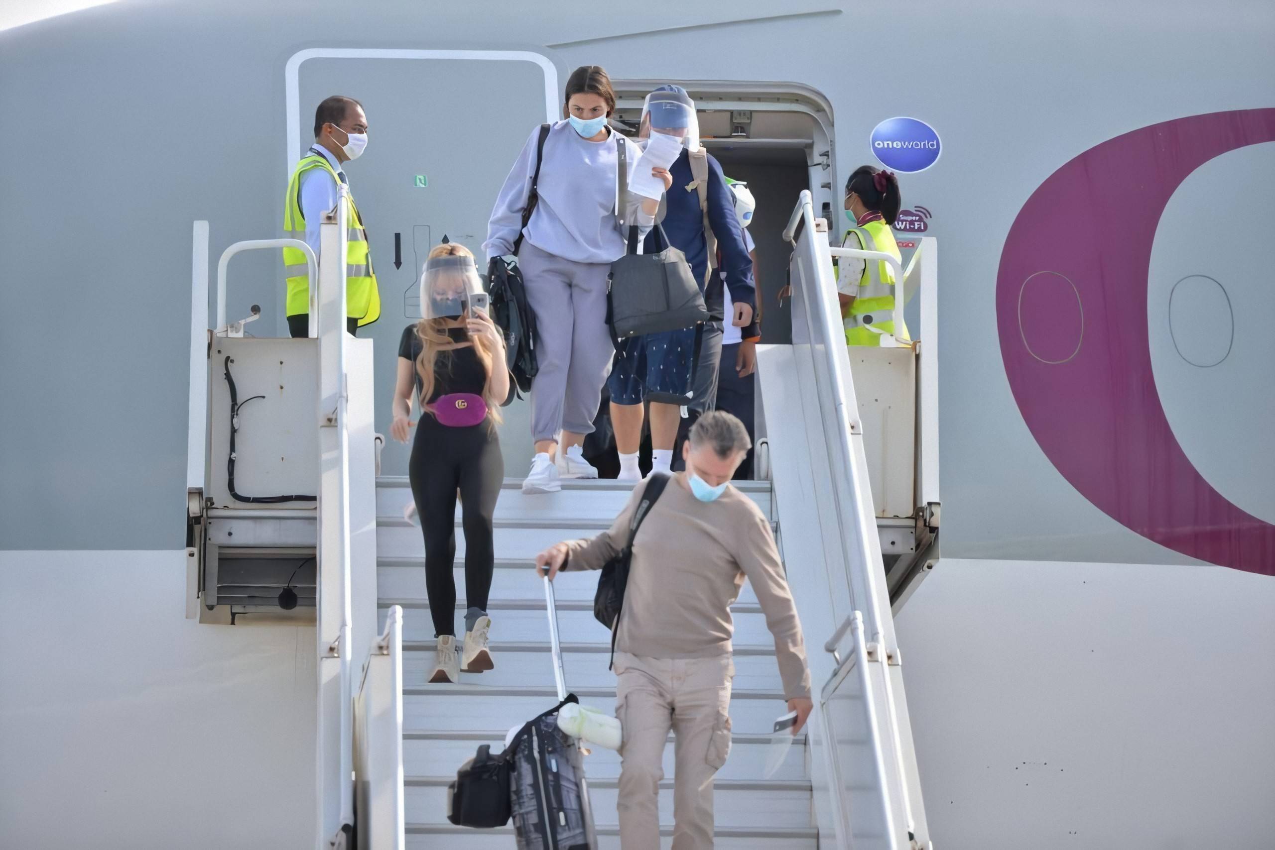 7月15日,在马尔代夫维拉纳国际机场,戴口罩的旅客走下飞机.