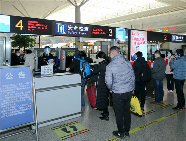 1月18日,在郑州东站安检口,民警使用体温自动测量仪对进站旅客测量