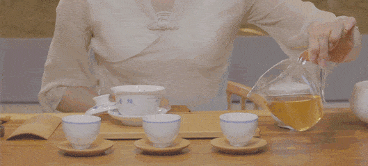 拇指,中指按住盖纽,快速倾倒碗身,将茶汤