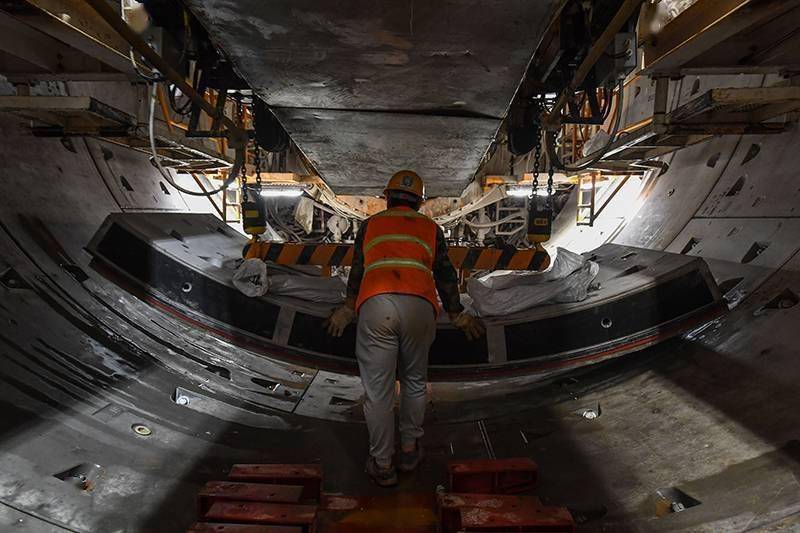 4月28日,施工人员在深圳地铁14号线共建管廊大纵坡隧道运输管片.