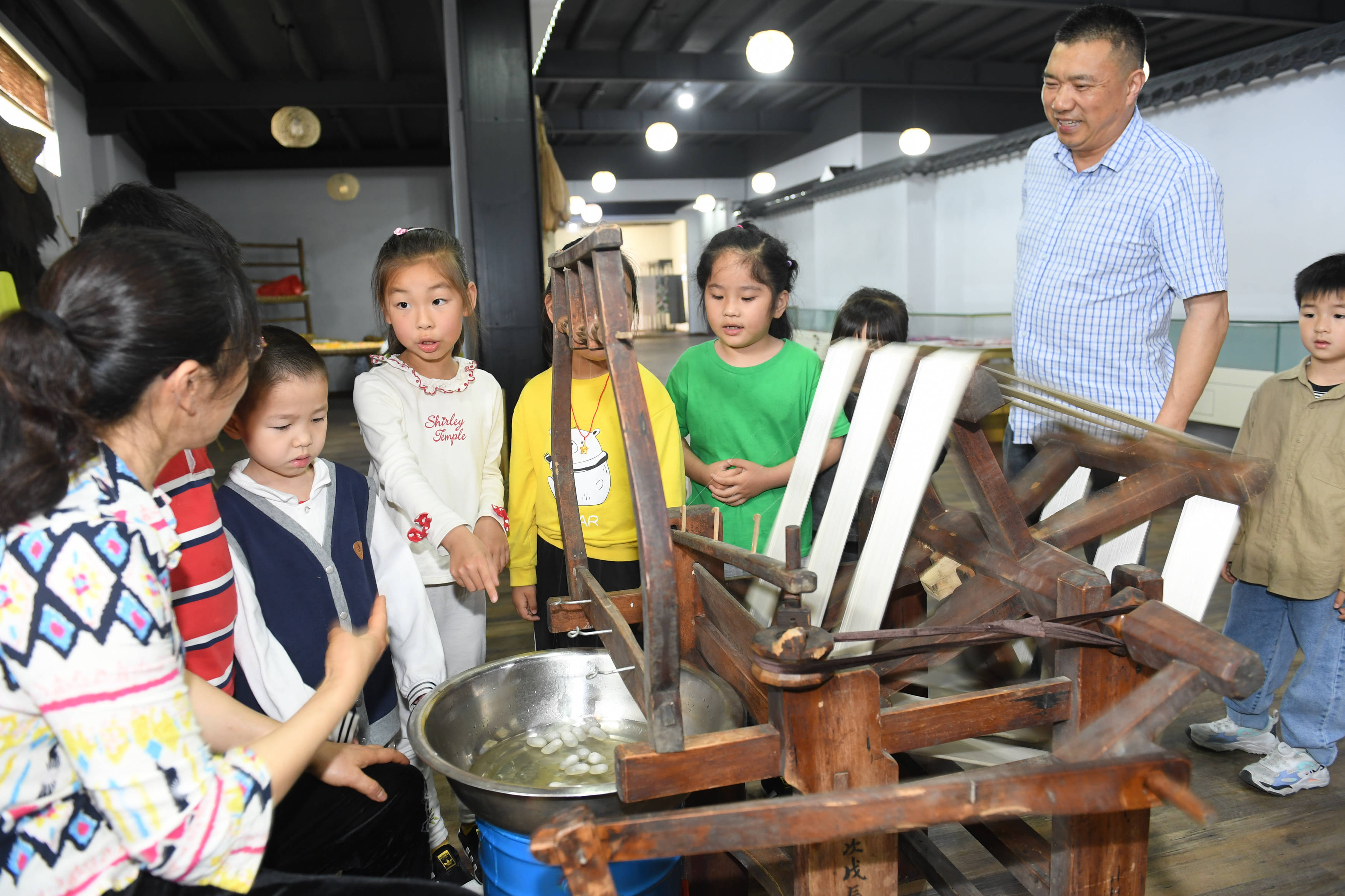 八里店镇丝绸记忆馆,湖州市实验幼儿园的孩子向工作人员询问缫丝流程