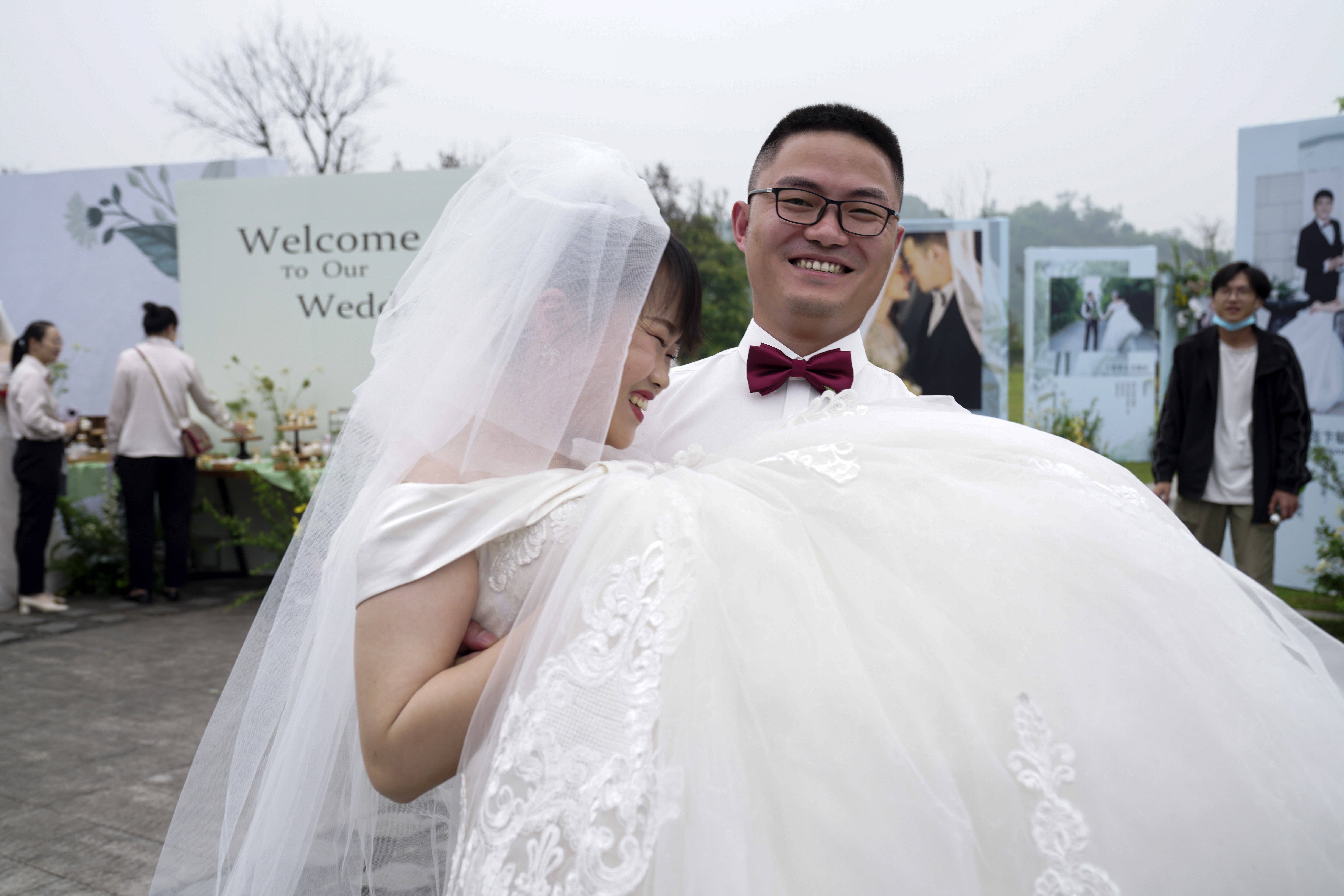 日,在重庆市北碚区中铁二十二局五公司集体婚礼现场,一名新郎抱起新娘
