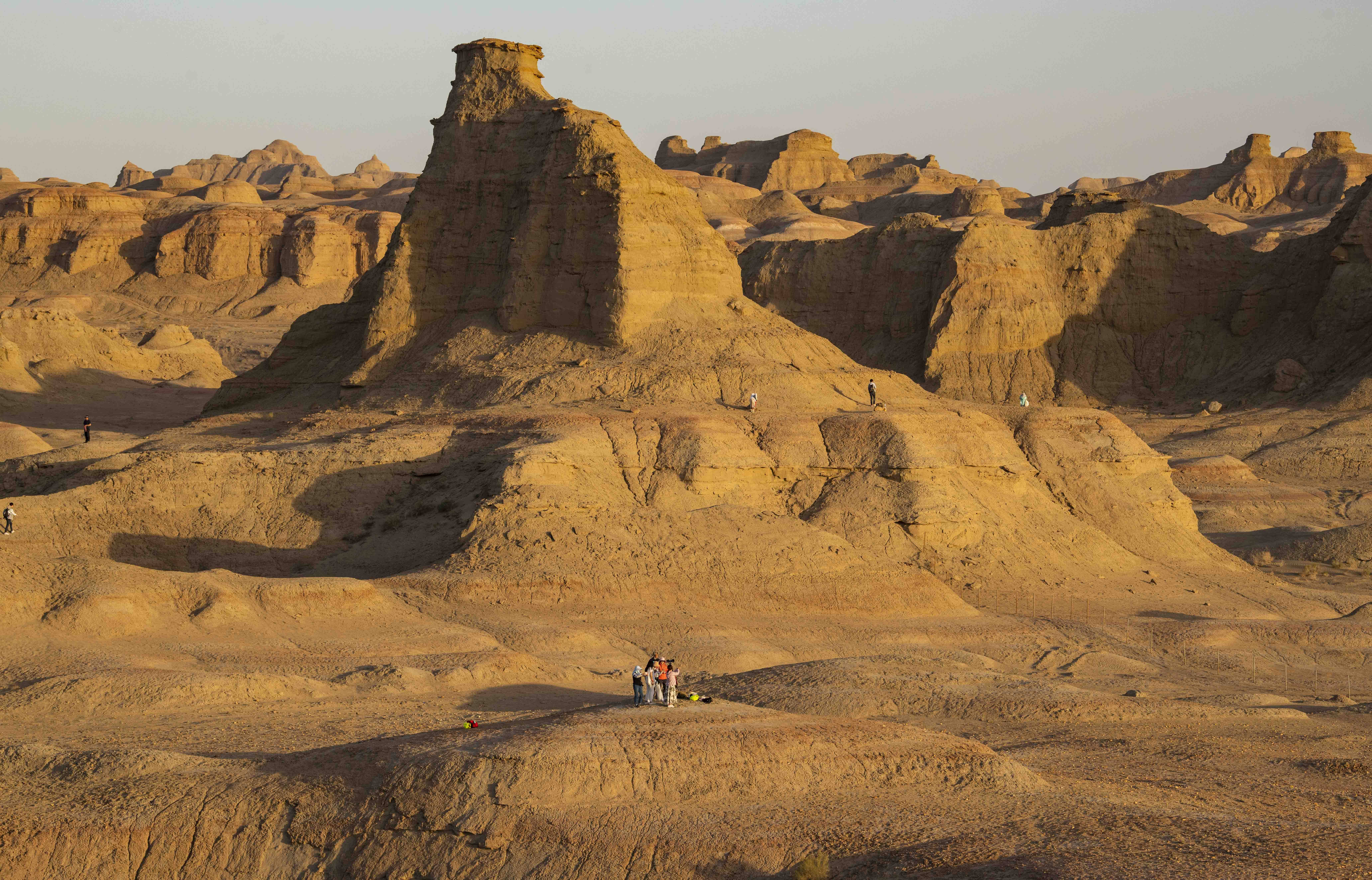 游客在新疆克拉玛依乌尔禾世界魔鬼城景区内拍照游玩(6月21日摄).