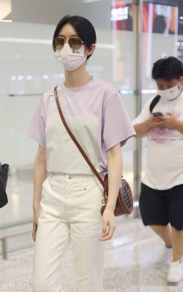 傅菁墨镜口罩遮面低调现身机场身着粉紫色 搭配白色休闲裤休闲随性