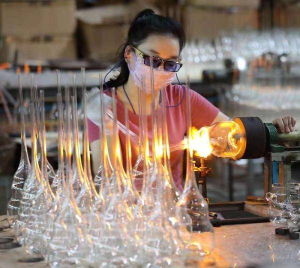 河间市一家工艺玻璃制品生产企业工人在车间加工工艺玻璃器皿.