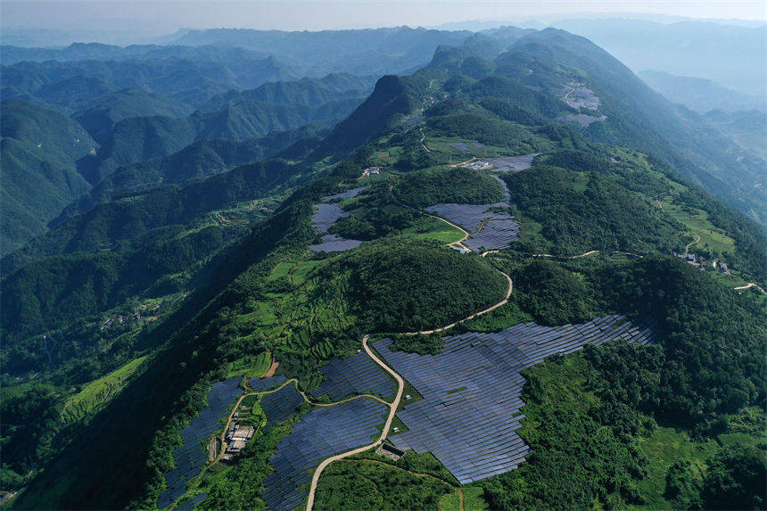 重庆市黔江区麒麟盖山地光伏发电板与群山,民居,农田相掩映,美如画卷.