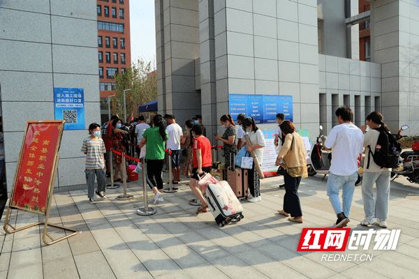 南县洗马湖学校大门口,学生们陆续前来入学报到.