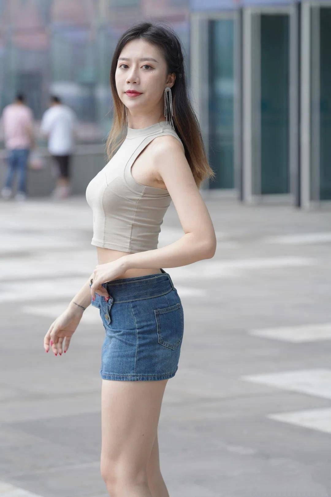 弧度 短款无袖背心搭配牛仔短裙，凸显香肩、小蛮腰和美腿，魅力炸街