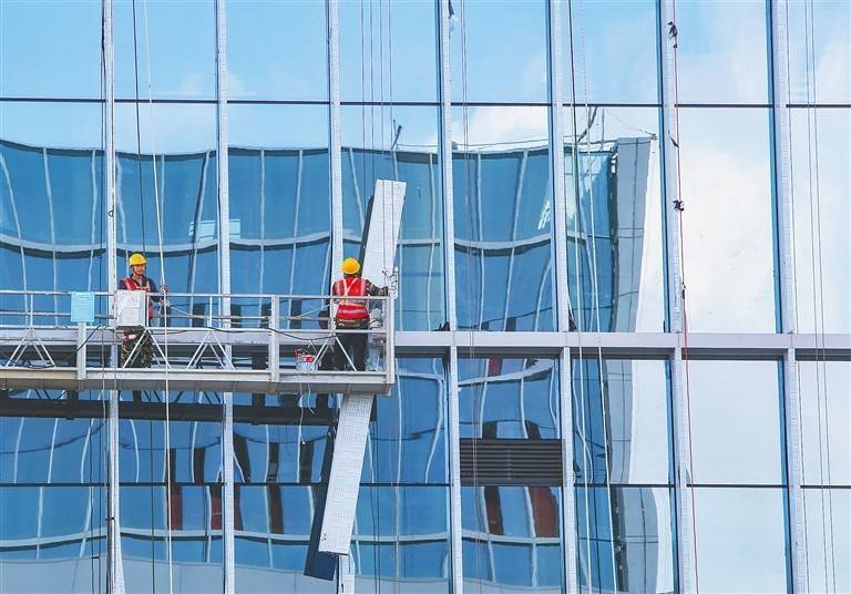 在深海科技创新公共平台项目施工现场，工人在安装幕墙。海南日报记者 王