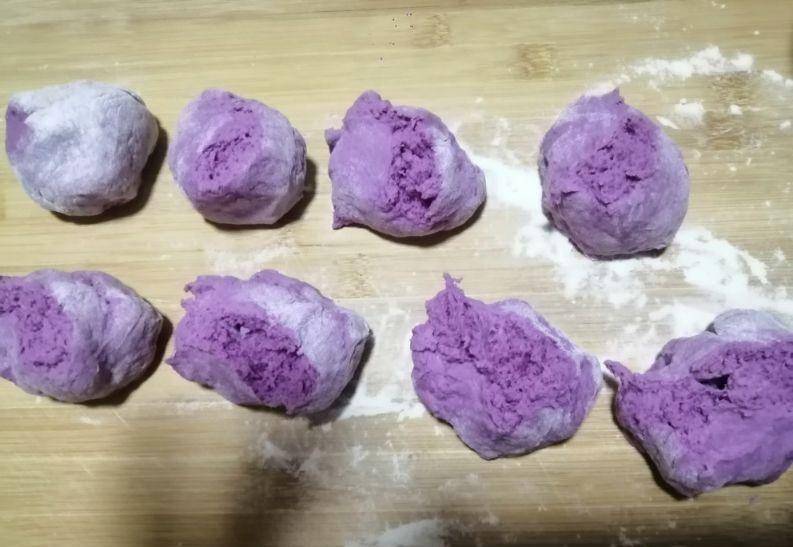然后像图中一样,在紫薯包子外面包一层白面皮.口朝下,整理