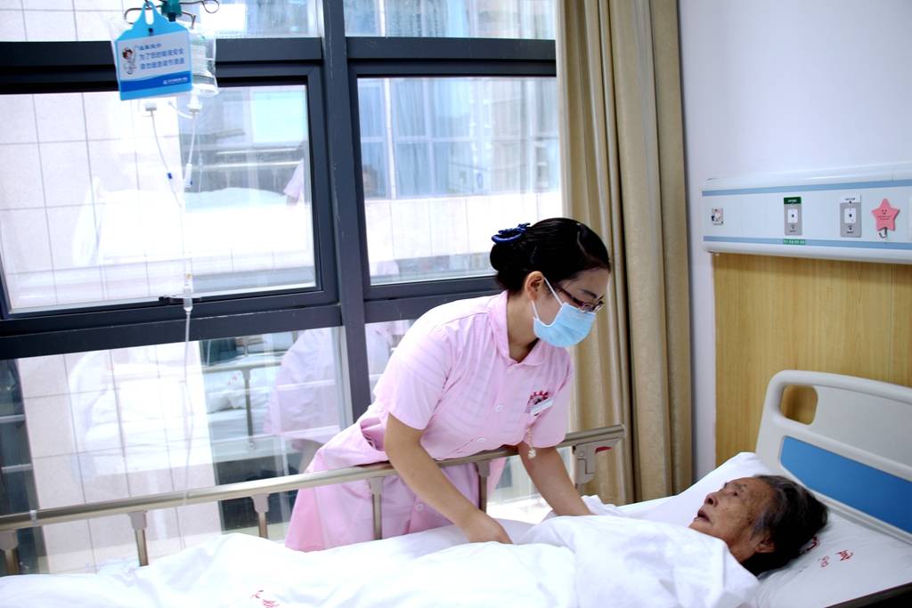 长航东院内科的护士小姐姐和老年患者亲切交谈.