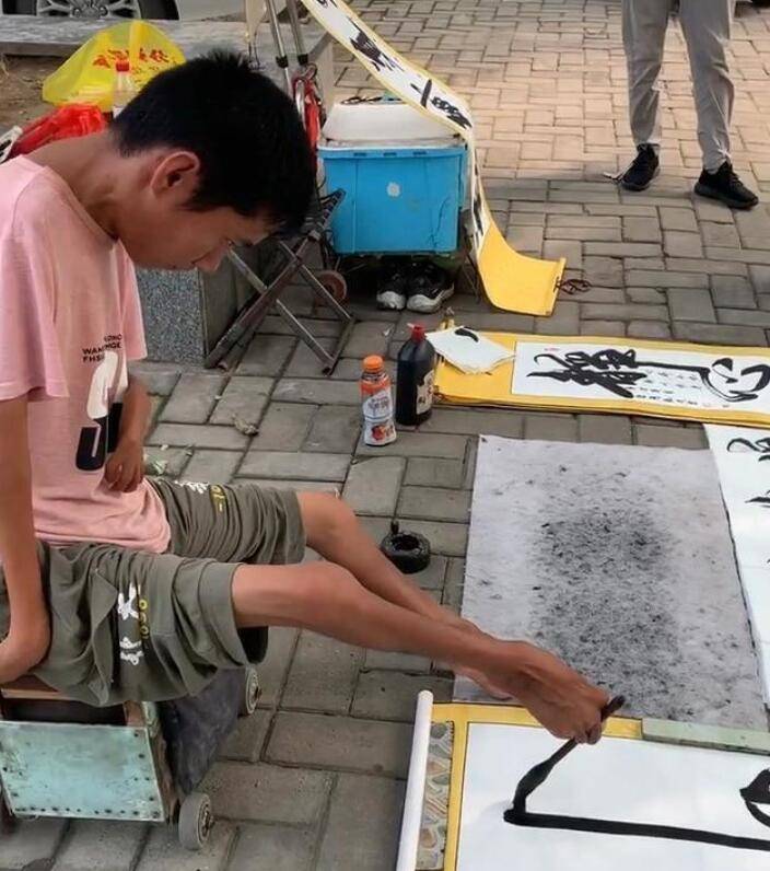 小儿麻痹患者用"脚"写书法,字体潇洒飘逸,路人纷纷称赞!_中国