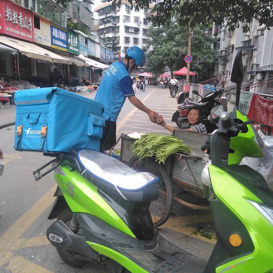 正在路边买菜的饿了么外卖小哥