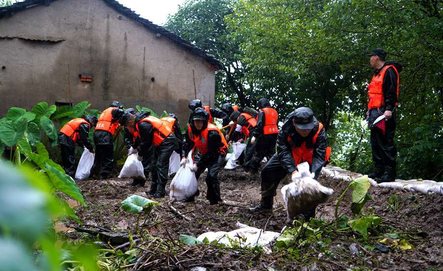 抗洪一线的武警:在雨中进食 累了就躺在堤坝上休息