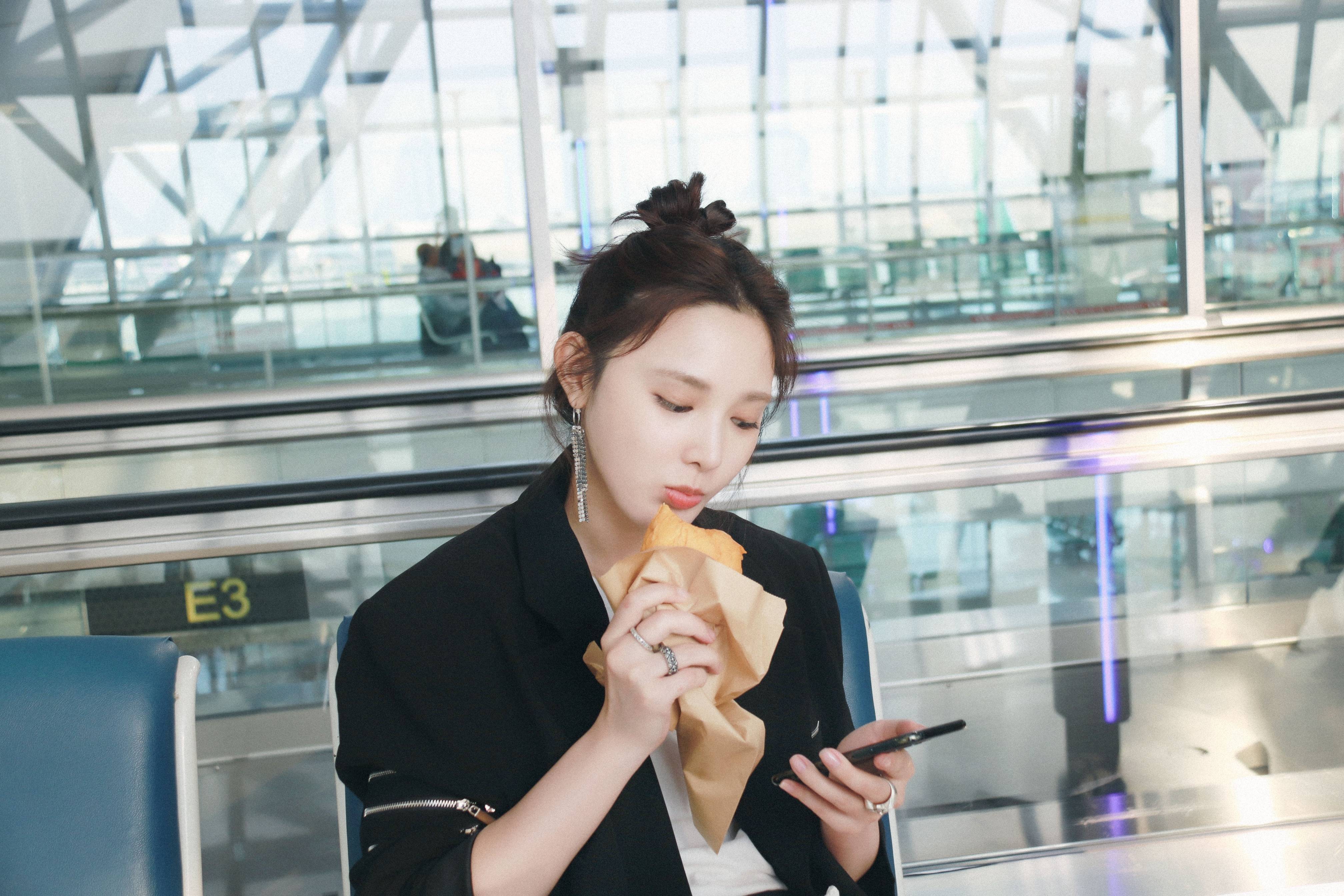 彭小苒机场吃牛角包西装造型时髦吸睛单边银色耳环甜美帅气