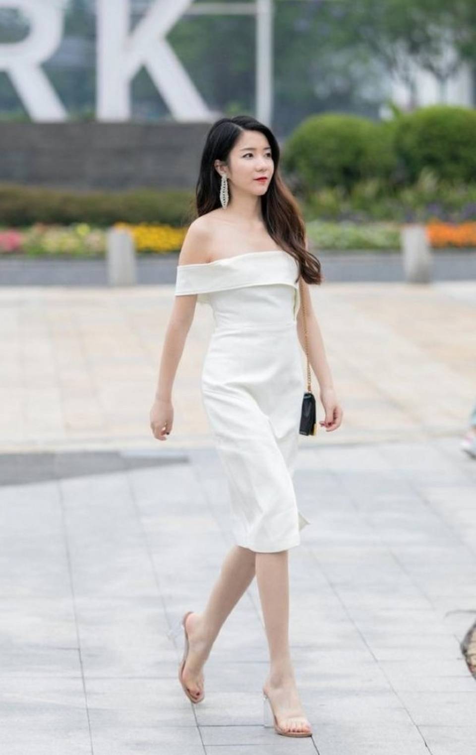 路人街拍美女搭配白色一字领连衣裙露出精致的锁骨线条