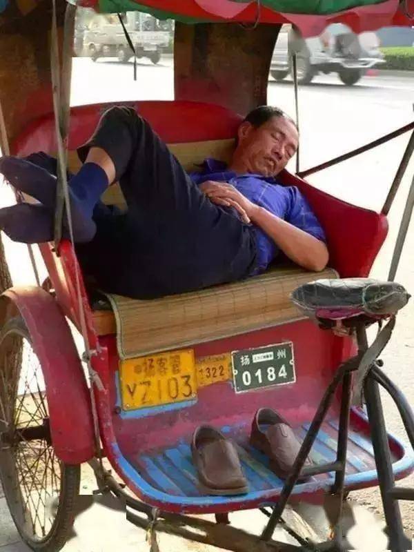 熟睡的三轮车夫街头小贩头靠竹椅睡着了