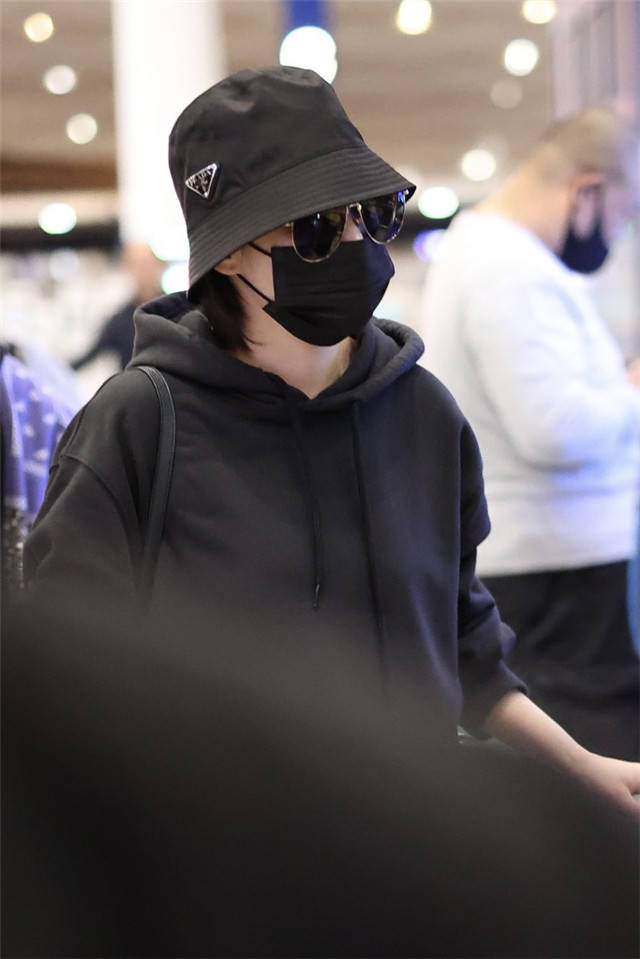 她的齐耳短发乖顺地垂在耳边,她戴着黑色的口罩和墨镜,几乎把整张脸