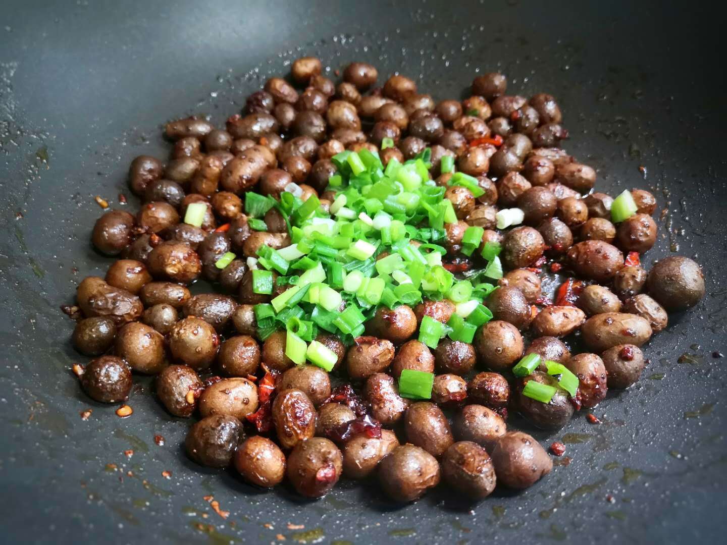 7,翻炒山药至山药豆表皮起皱,放入切好的葱花.