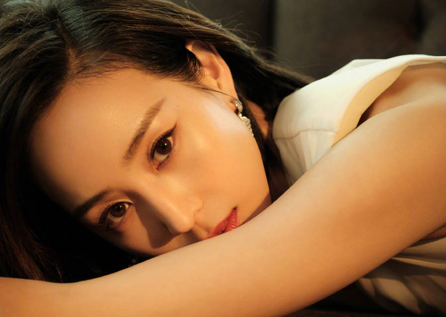 张钧甯穿白色深v钉珠礼裙 倚靠沙发演绎慵懒性感风