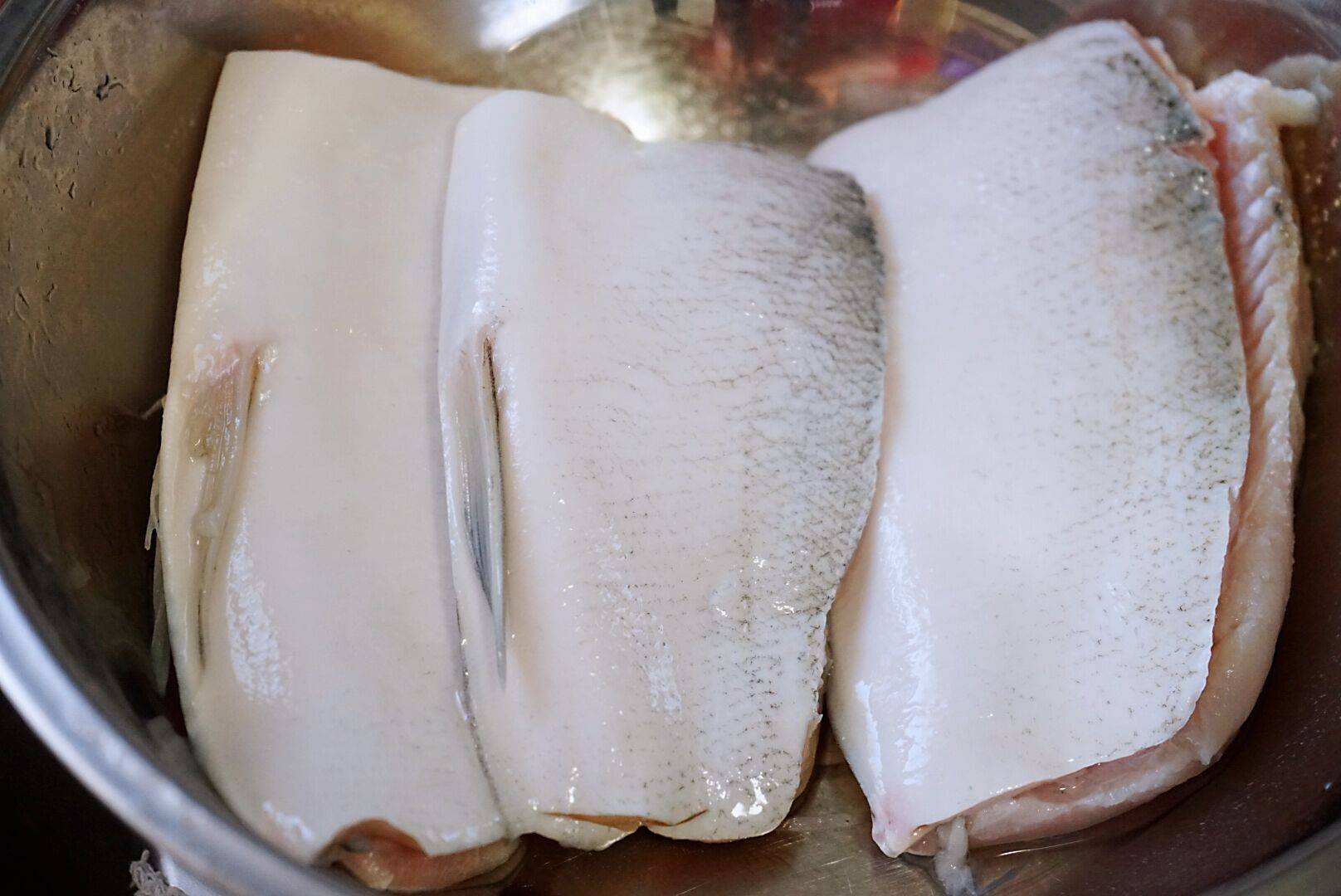 1,一斤的鱼腩肉,洗净后切块,放入碗中后来一大勺料酒,少许白胡椒粉,一