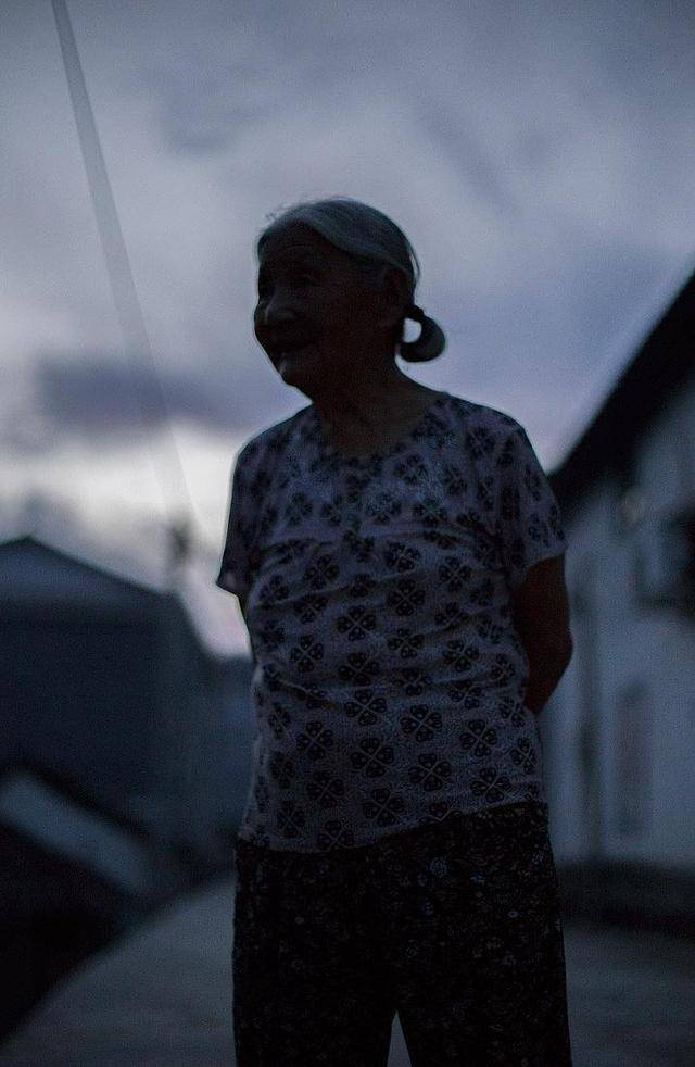 母亲站在村口望着女儿女婿远去的身影发呆,心疼得泪眼婆娑.