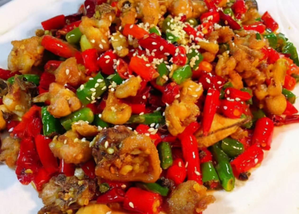 加朝天椒炸出红色的辣椒油后加入泡椒和蒜片,再放猪肝,爆炒加盐,鸡粉
