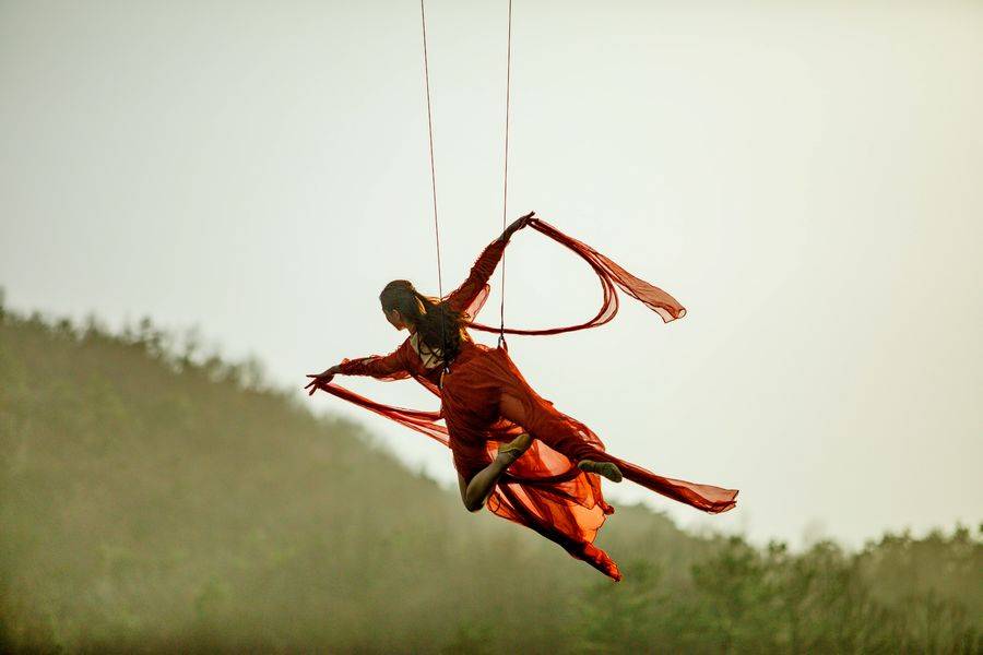 红衣少女在蓝天下演绎"空中芭蕾"飘逸 优雅(美图分享)