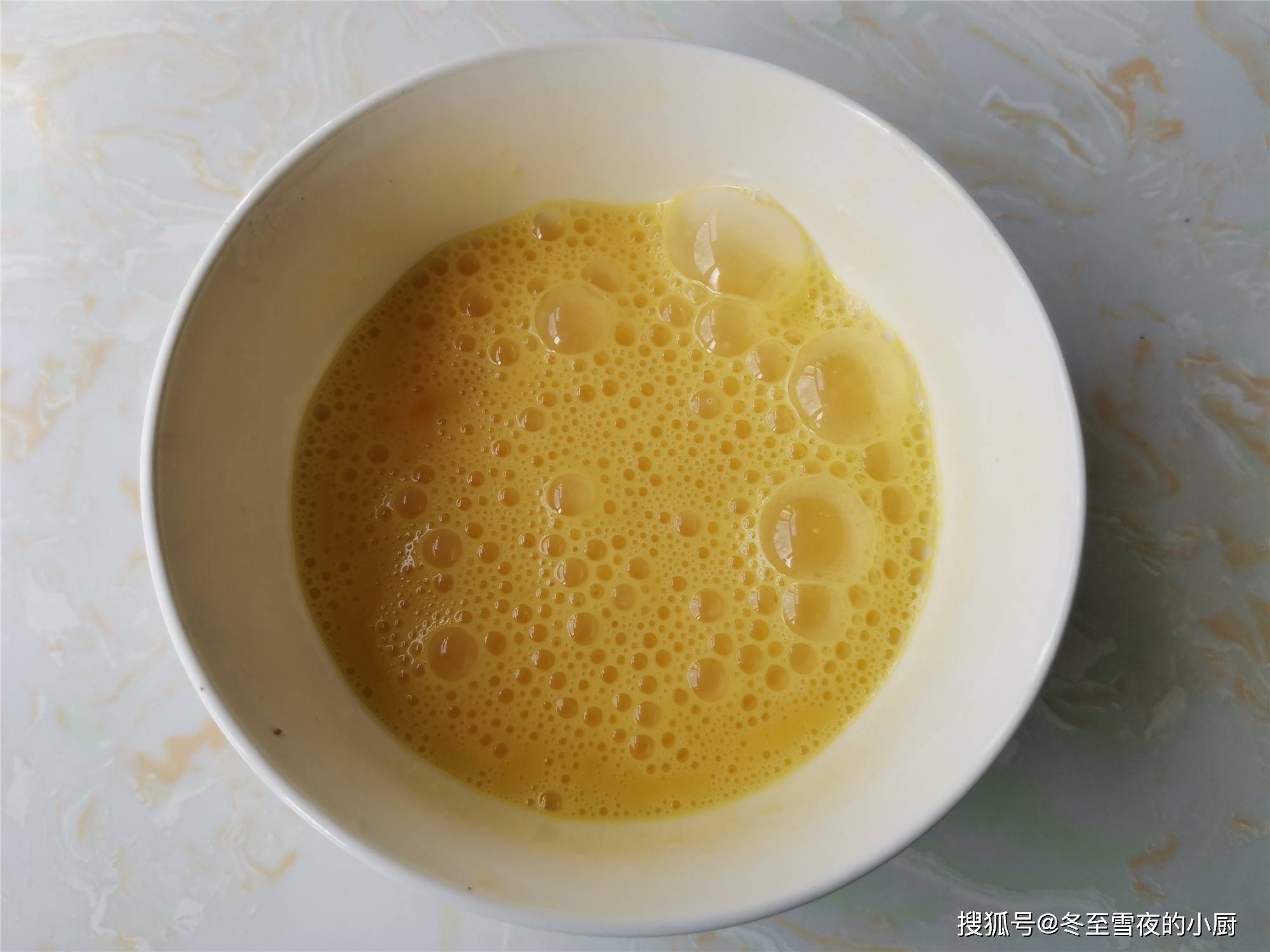 3.把鸡蛋磕入碗内,用筷子把蛋液搅打均匀.