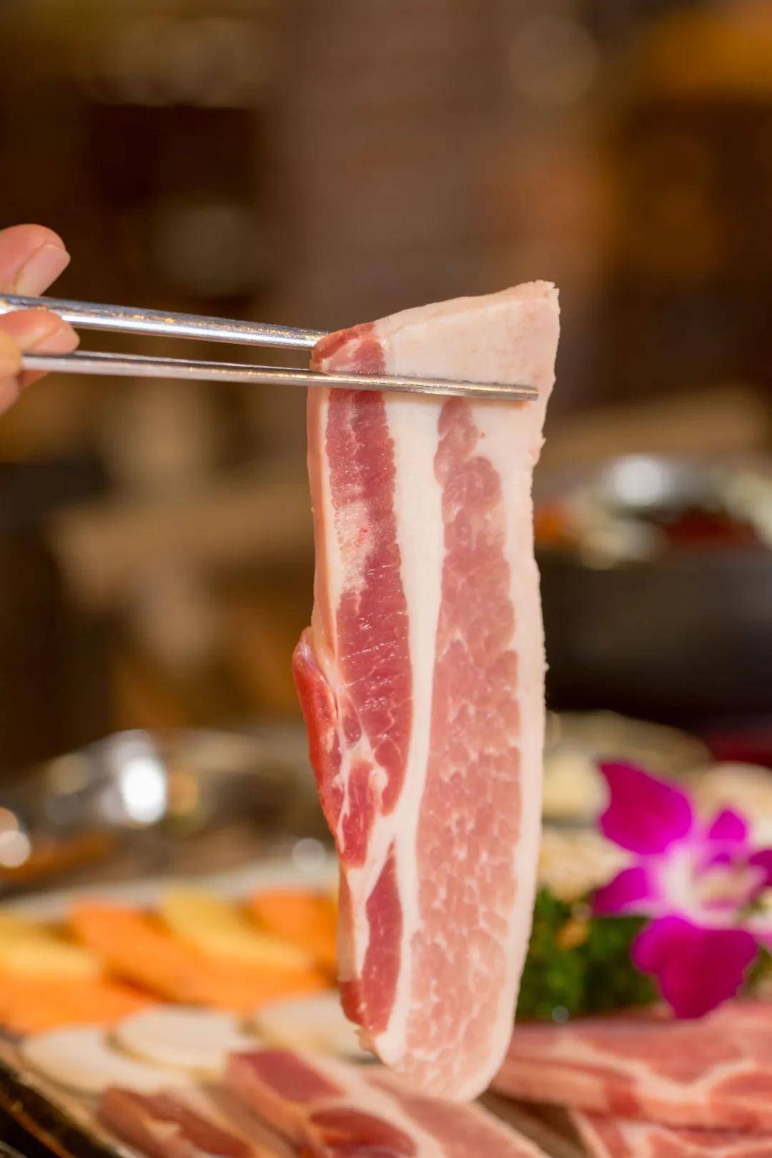 将五花肉放到烤盘上烤得滋滋作响后,油花迸发出来,这时的五花肉很是