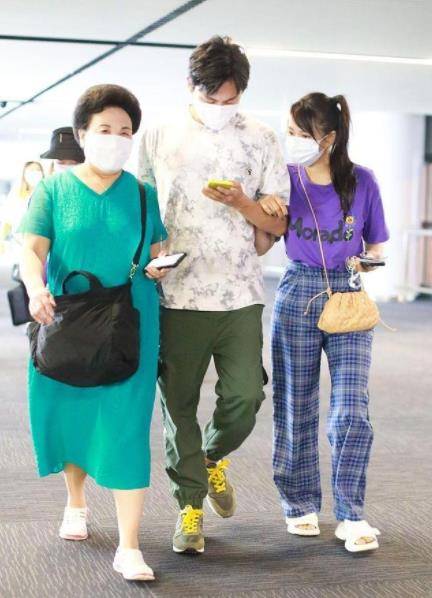 青春 伊能静牵老公现身机场,卷发配牛仔裤青春减龄,两人看不出年龄差