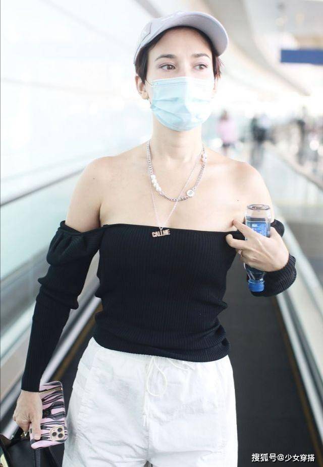 显得 卢靖姗走机场真放得开，方领针织衫硬拽成一字肩，意外时髦洋气