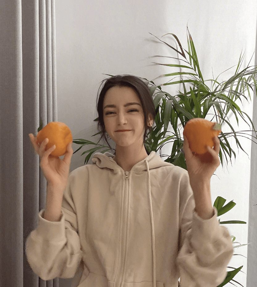 迪丽热巴晒生活照，将橘子放在头顶搞怪摆拍，