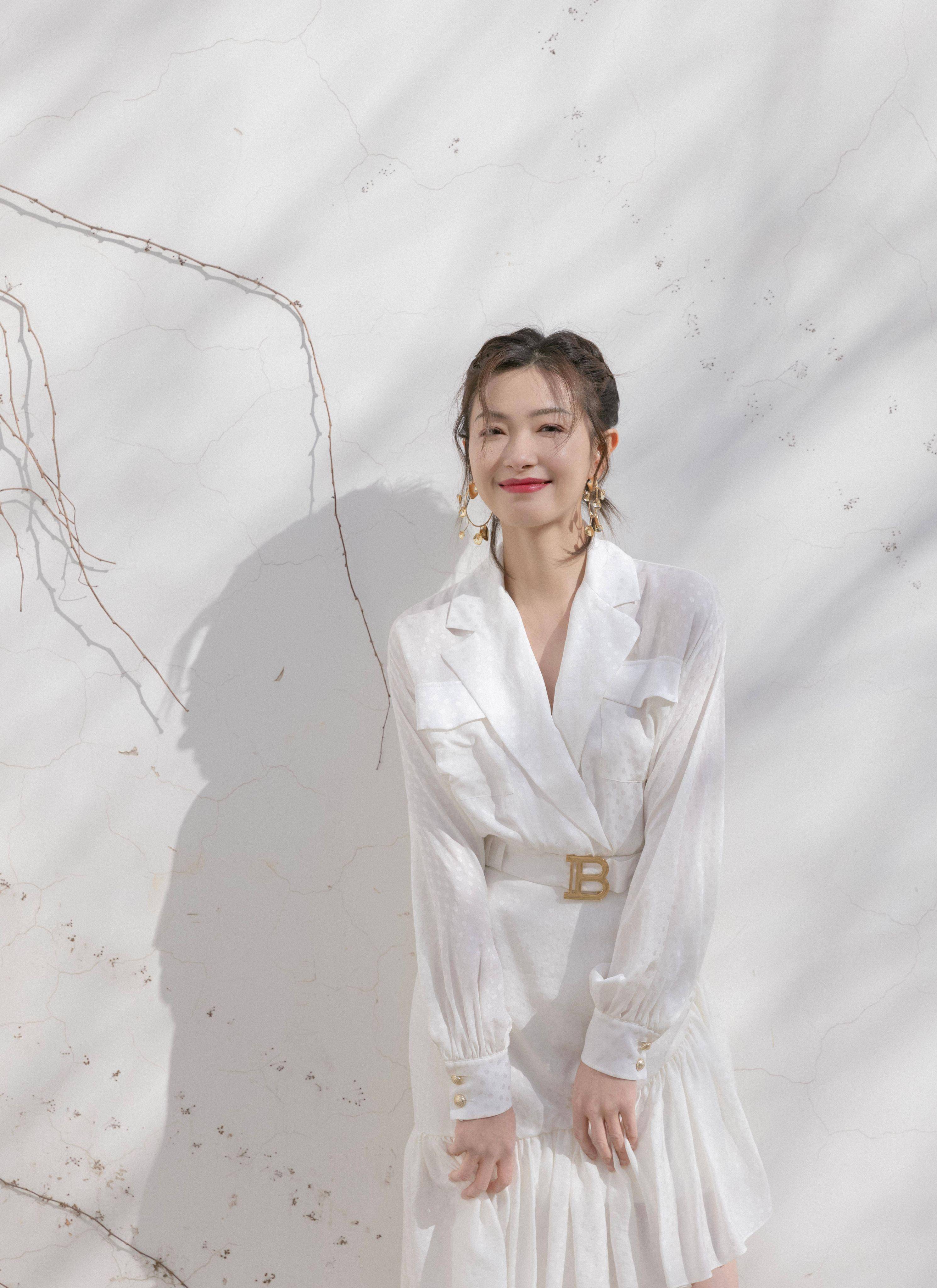 原创万茜手臂受伤走出机场热裤背心外加长外套走路带风