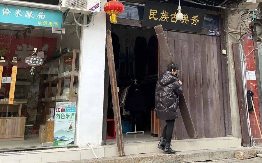 老板娘在下门板,这种老式门板如今只在老街见得到了.