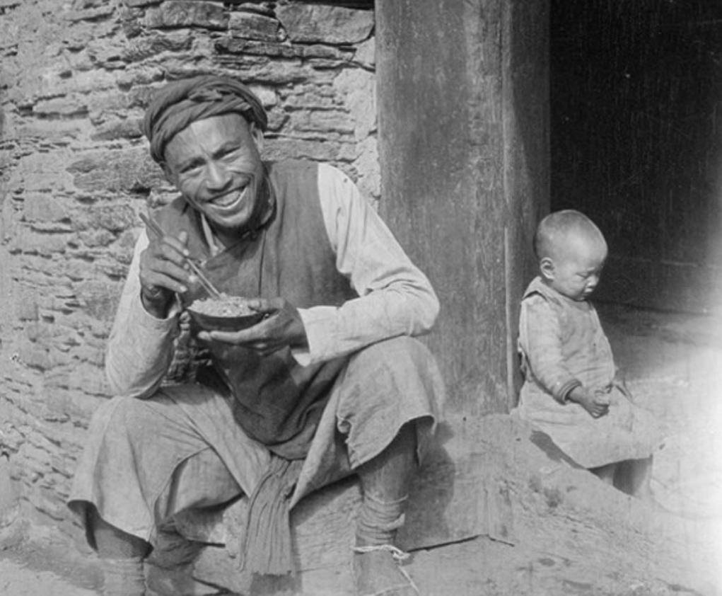 晚清老照片：父子赤脚穿草鞋坐在门前吃饭，寨子里的女人很美丽！