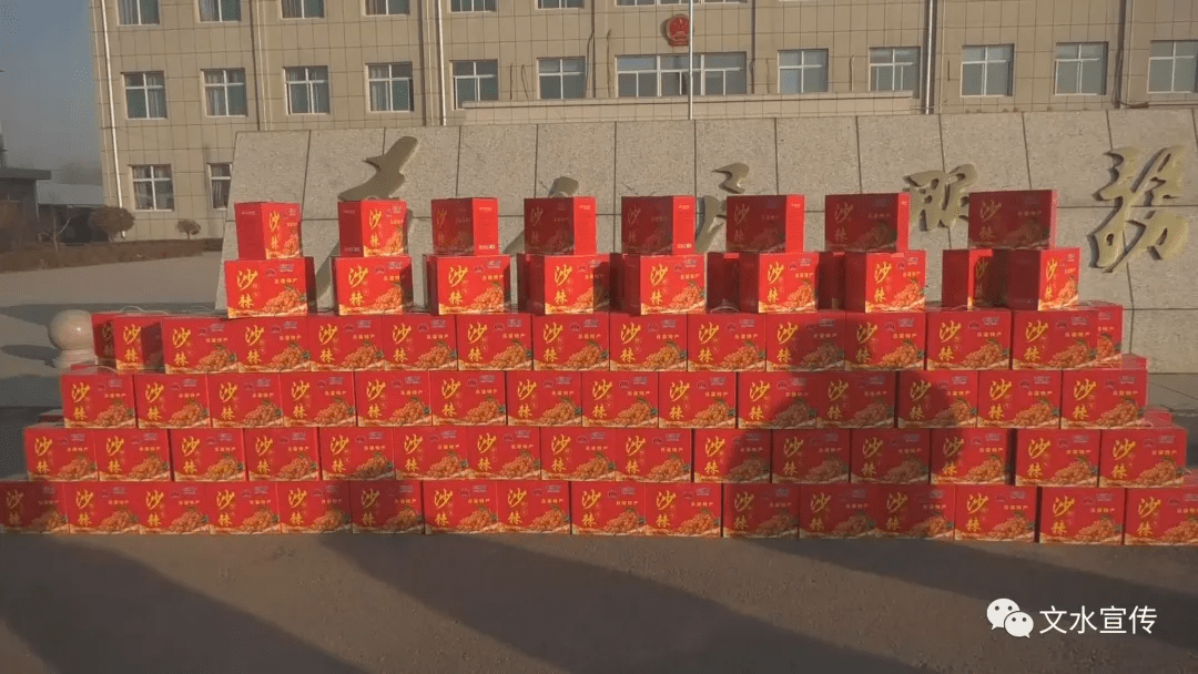 圣益饮料公司捐助的300多箱沙棘饮料整齐摆放,前来领取慰问品的65岁