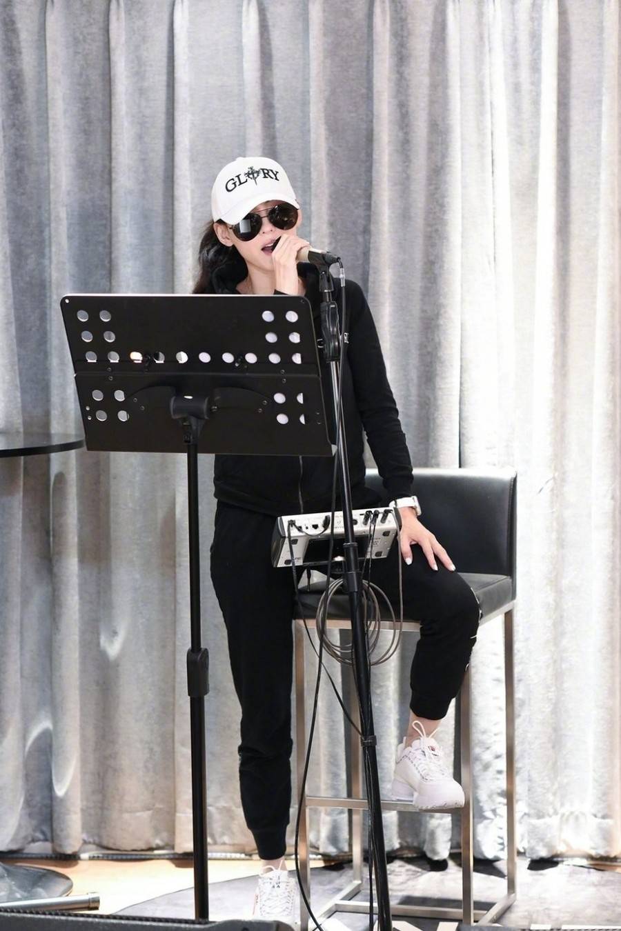 黑色 张柏芝低调走机场，丸子头配红衣口罩也遮不住美貌，38岁美得像18