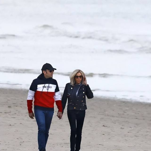 原创马克龙携妻海滩漫步十指紧扣太甜布丽吉特穿皮衣搂着腰太恩爱