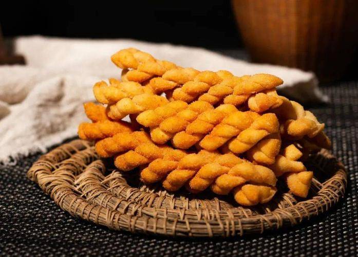 麻花是汉族的特色小吃把两三股条状的面拧在一起用油炸熟即可