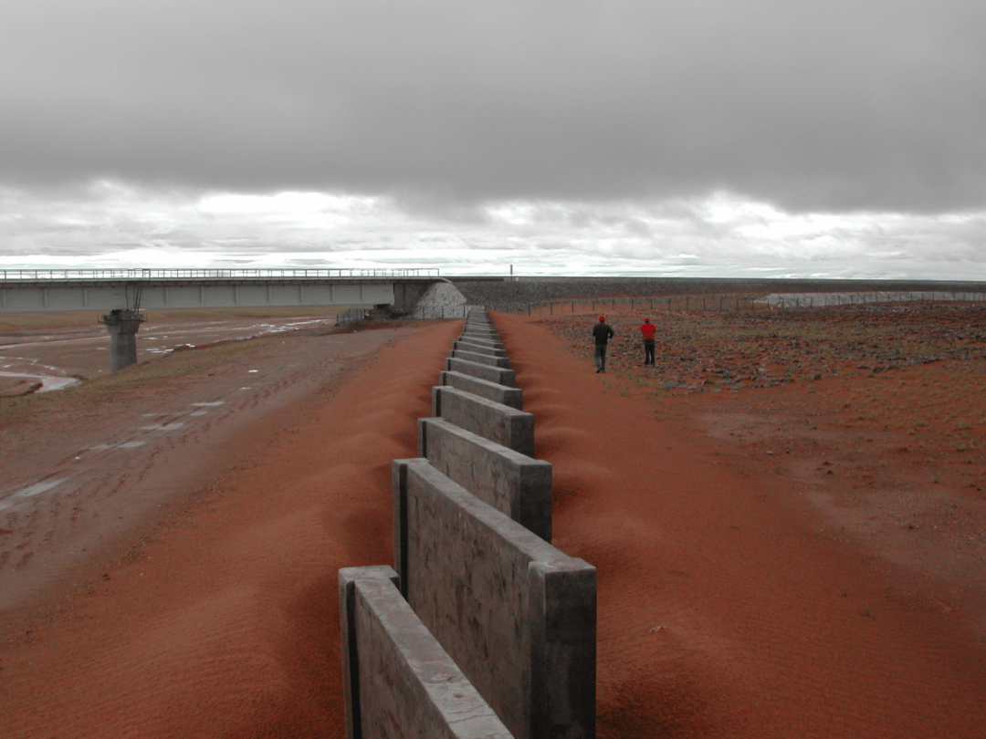 为防止"就地起沙",建设者采取平铺卵石土,设置石方格沙障固,阻沙;风沙